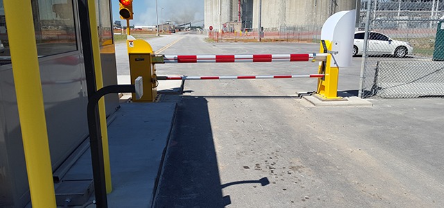 Security barrier with red and white striped arm, used to restrict vehicle access.